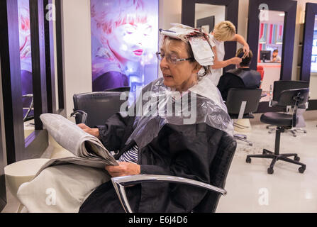 OLDER WOMAN IN HAIR SALON HAVING HAIR CUT AND STYLED BY HAIRDRESSER ...