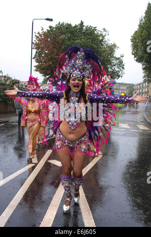 London, UK. 25th August, 2014. A woman in a purple and pink custume and headdress dances in the rain at the Notting Hill Carnival London, UK. Credit:  Mamusu Kallon/Alamy Live News Stock Photo