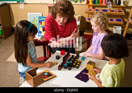 5-6 year old diverse multicultural multi ethnic helping group three multiethnic pre-k work together team teamwork cooperating project high angle from above Stock Photo