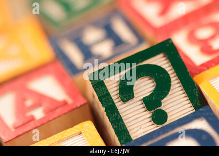 Wooden, colorful educational blocks with selective focus on question mark. Stock Photo