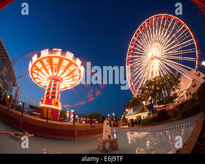 A night, fisheye view of the popular Wave Swinger and Ferris Wheel rides at Navy Pier in Chicago. Stock Photo