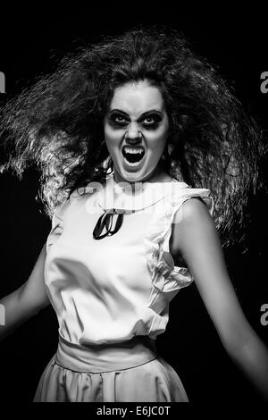 angry screaming crazy vampire woman in dark, monochrome image Stock Photo