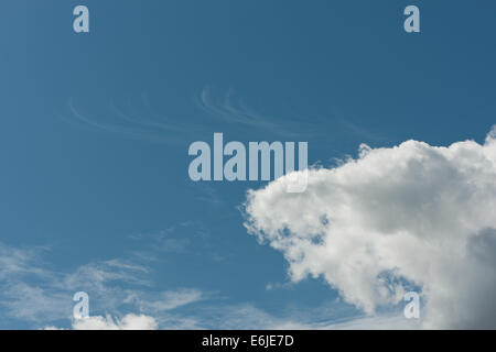 skyscape of dramatic puffy cotton wool cloud cumulus with higher altostratus and high altitude cirrus against deep blue sky Stock Photo