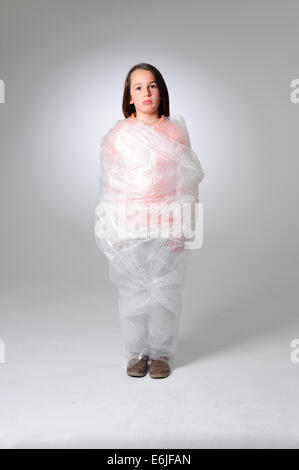 EDITORIAL ONLY - Over protection parenting helicopter parents kid wrapped in bubble wrap to protect from hurt or injury Stock Photo