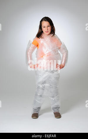 EDITORIAL ONLY - Over protection parenting helicopter parents kid wrapped in bubble wrap to protect from hurt or injury Stock Photo