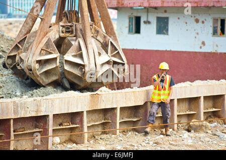 Engineer Supervises The Dredging Of The Causeway Bay Typhoon Shelter, Hong Kong. Stock Photo