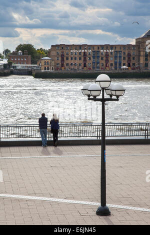 Two people looking at the Thames River in London's Canary Wharf Stock Photo