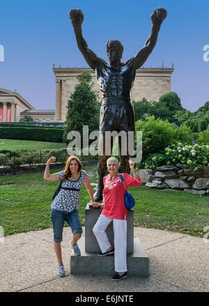 Tourists pose with the Rocky statue in from of the Philadelphia Museum of Art. Stock Photo