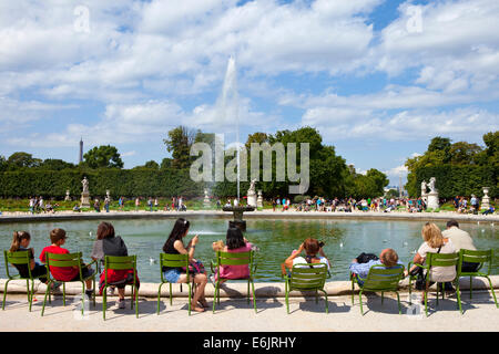 PARIS, FRANCE - AUGUST 4TH 2014: People relaxing around a fountain in the beautiful Jardin des Tuileries in Paris on the 4th Aug Stock Photo