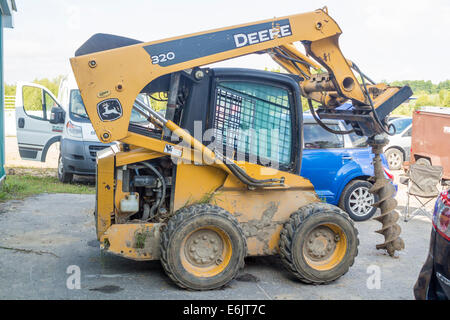 Johm Deere skid steer with attached auger. Stock Photo