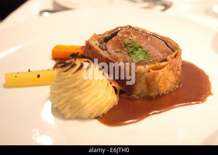 Beef wellington with mashed potatoes carrots and gravy Stock Photo