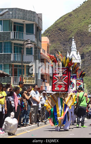 People watching the colorful traditional carnival parade on Ambato street in Banos, Ecuador Stock Photo