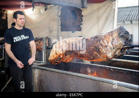 Man roasting whole pig on a spit Stock Photo