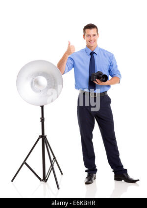 cheerful young photographer giving thumb up on white background Stock Photo