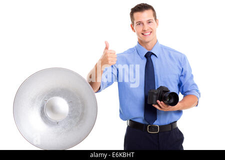 handsome young photographer giving thumb up on white background Stock Photo