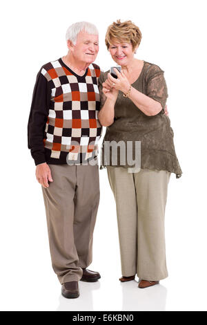 lovely senior couple using smart phone on white background Stock Photo