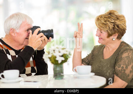 elderly man photographing his wife with a digital camera Stock Photo