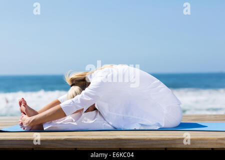 healthy mid age woman stretching outdoors Stock Photo