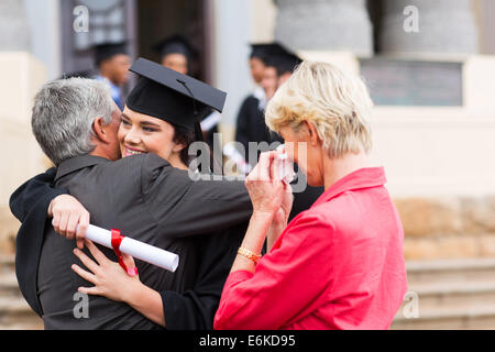 beautiful young female graduate hugging her father at graduation Stock Photo