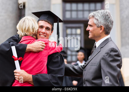 happy male graduate hugging his mother at graduation ceremony Stock Photo