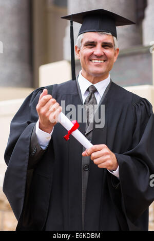 smiling middle aged male graduate in front university building Stock Photo