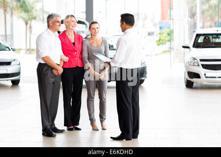 vehicle salesman explaining contract to family before purchasing a car Stock Photo