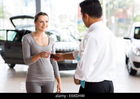young woman receiving her new car key from salesman Stock Photo