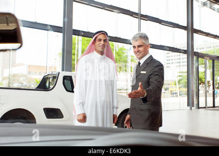 handsome senior car salesman selling a car to Arabic man Stock Photo