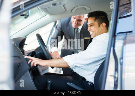happy Indian man checking car features at showroom Stock Photo