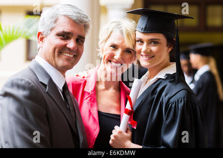 beautiful female college graduate with parents on graduation day Stock Photo