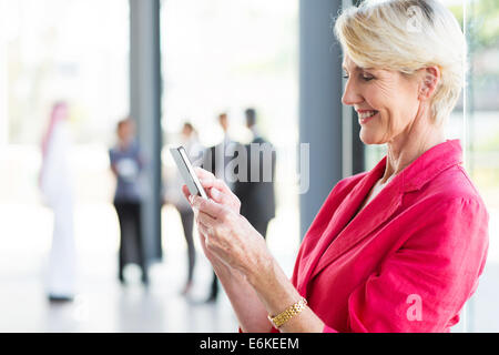 beautiful middle aged businesswoman reading email on smart phone Stock Photo