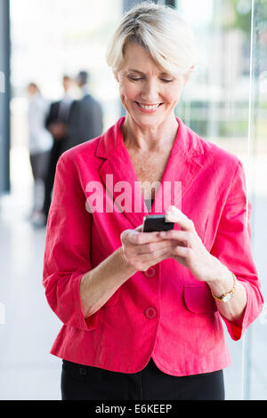 happy senior businesswoman using smart phone in office Stock Photo