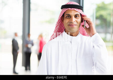 smiling Arabian businessman talking on cell phone Stock Photo