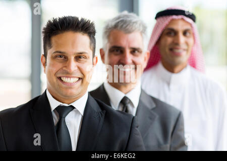 three smiling businessmen standing in a row Stock Photo