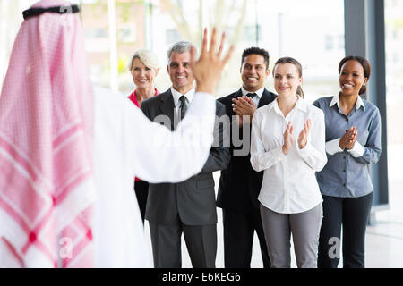 business team applauding to welcome Arabian business partner Stock Photo