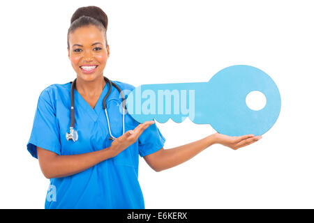 cheerful African medical intern doctor holding a large toy key Stock Photo