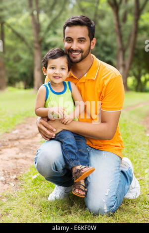 happy Indian father and son outdoors in forest Stock Photo