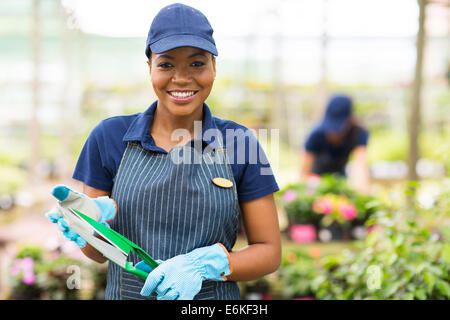 pretty young African gardener portrait in greenhouse Stock Photo