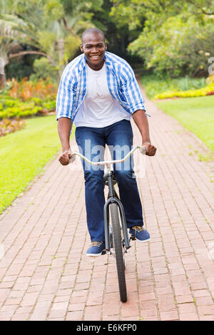 happy African American man riding bicycle outdoors Stock Photo