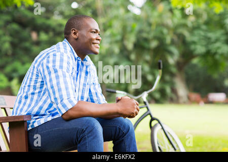 handsome young African man sitting outdoors Stock Photo