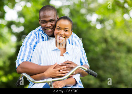 happy African couple on one bike relaxing in forest Stock Photo