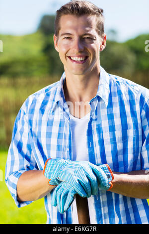 happy young man relaxing in home garden after doing garden work Stock Photo