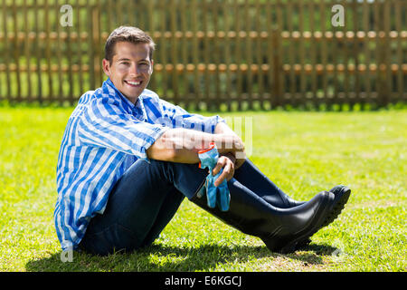 good looking gardener sitting on lawn Stock Photo