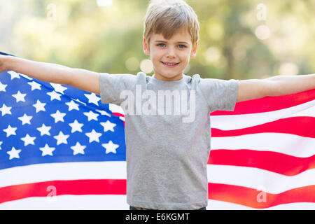 portrait of cute little boy holding American flag outdoors Stock Photo