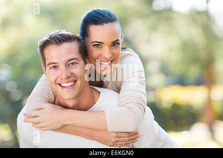 attractive young couple piggybacking outdoors Stock Photo