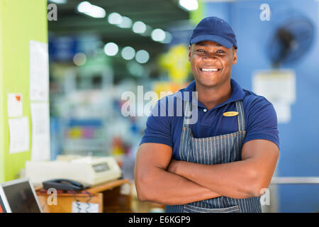 handsome African supermarket cashier standing at checkout Stock Photo