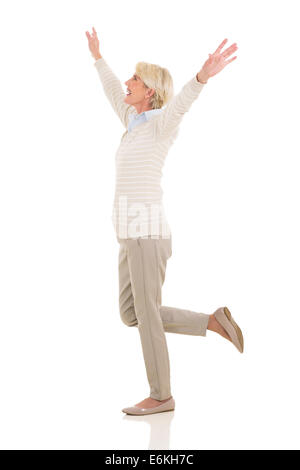 side view of happy mature woman looking up with arms open Stock Photo