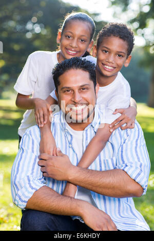 portrait of happy Indian father and kids outdoors Stock Photo