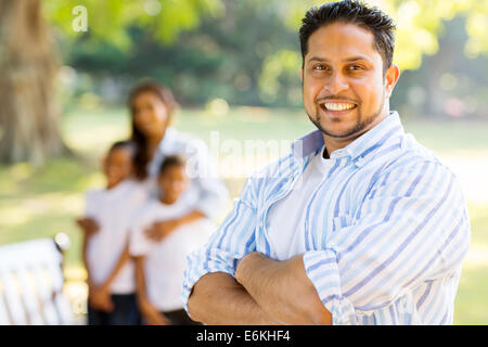 good looking young Indian man standing in front of family outdoors Stock Photo