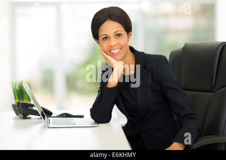beautiful mature African businesswoman relaxing in office Stock Photo